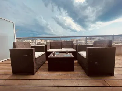a balcony with chairs and a table on a roof at Grand studio toit terrase Ajaccio in Ajaccio