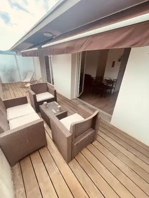 a balcony with couches and a table on a deck at Grand studio toit terrase Ajaccio in Ajaccio