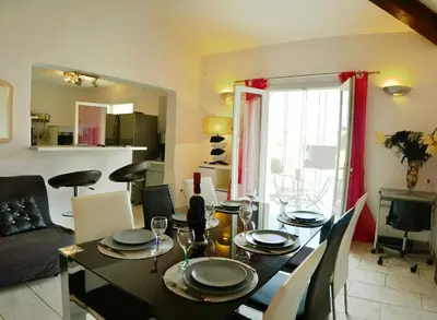 a living room with a table and a dining room at Résidence MARI in Folelli