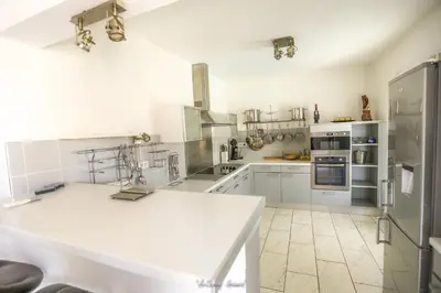 a kitchen with white cabinets and a white counter top at Résidence MARI in Folelli