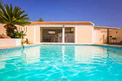 a swimming pool in front of a house at Résidence MARI in Folelli