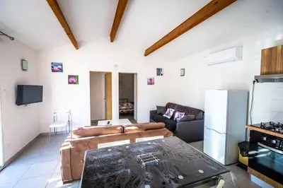 a kitchen and living room with a couch and a table at Résidence MARI in Folelli