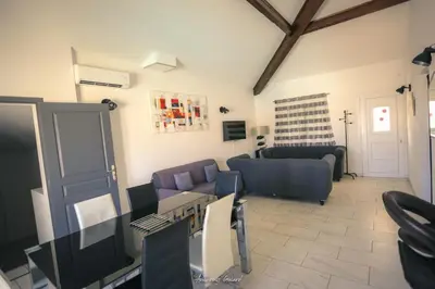 a living room with a couch and a table and chairs at Résidence MARI in Folelli