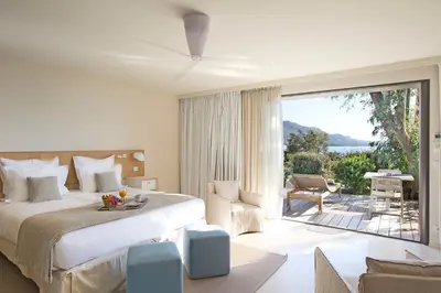 a bedroom with a large bed and a large window at La Plage Casadelmar in Porto-Vecchio