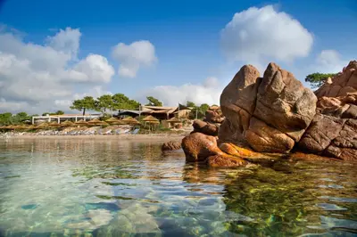 a view of a beach with rocks in the water at La Plage Casadelmar in Porto-Vecchio