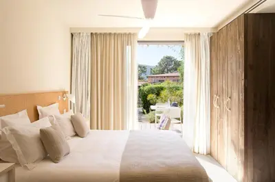 a bedroom with a large bed and a large window at La Plage Casadelmar in Porto-Vecchio