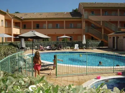 two children standing next to a swimming pool at Grazioso bilocale a 200 m dal mare in residence con piscina e WI-FI in Linguizzetta