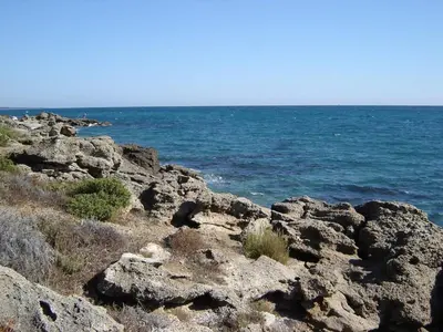 a group of rocks with the ocean in the background at Grazioso bilocale a 200 m dal mare in residence con piscina e WI-FI in Linguizzetta