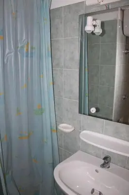 a bathroom with a sink and a shower curtain at Grazioso bilocale a 200 m dal mare in residence con piscina e WI-FI in Linguizzetta