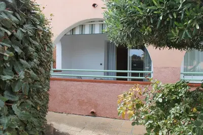 a building with a white door and a window at Grazioso bilocale a 200 m dal mare in residence con piscina e WI-FI in Linguizzetta