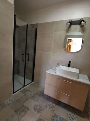 a bathroom with a sink and a shower and a mirror at Appartement 2 ou 4 personnes. Venaco in Venaco
