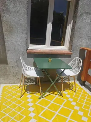 a green table and two chairs on a patio at Appartement 2 ou 4 personnes. Venaco in Venaco