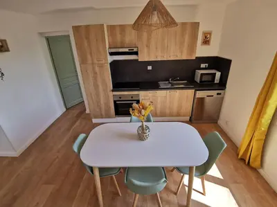a small kitchen with a white table and chairs at Appartement 2 ou 4 personnes. Venaco in Venaco