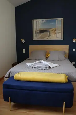 a bed with a blue ottoman in a bedroom at maison climatisée 150 m de la mer in Santa-Maria-Poggio