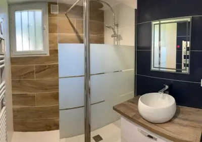 a bathroom with a sink and a glass shower at maison climatisée 150 m de la mer in Santa-Maria-Poggio