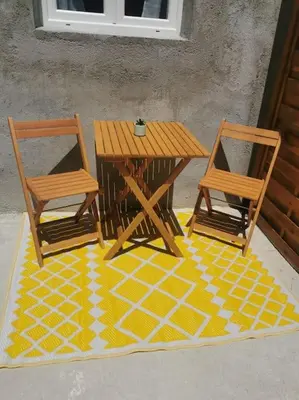 a wooden table and two chairs on a yellow floor at Appartement de 30m2 pour 2 personnes Venaco in Venaco