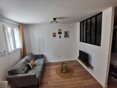 a living room with a couch and a television at Appartement de 30m2 pour 2 personnes Venaco in Venaco
