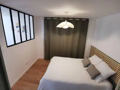 a bedroom with a bed and a large window at Appartement de 30m2 pour 2 personnes Venaco in Venaco