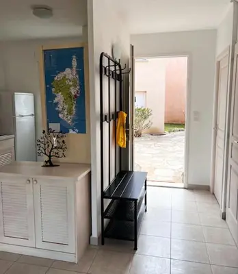 a kitchen with a black bench in a room at Villa avec terrasse et vue piscine, proche plage in Moriani Plage