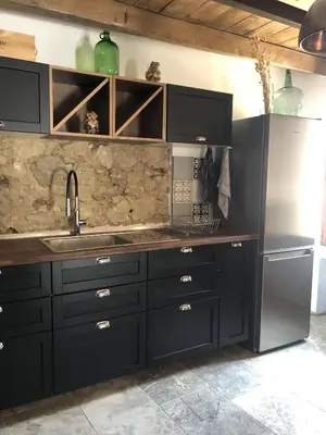 a kitchen with black cabinets and a sink at The Charming House in Ville-di-Paraso