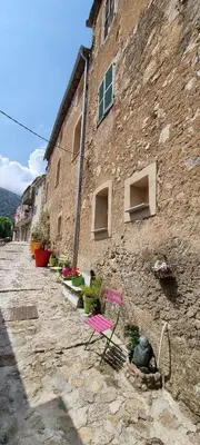 a stone building with potted plants on the side of it at The Charming House in Ville-di-Paraso