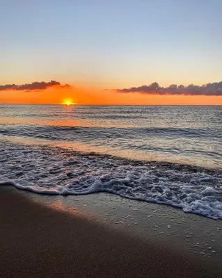 a sunset on a beach with the ocean and the waves at Le jardin de Domi in Ventiseri