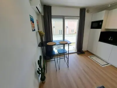 a room with a table and two chairs and a window at Beau studio proche centre ville et plage in Ajaccio