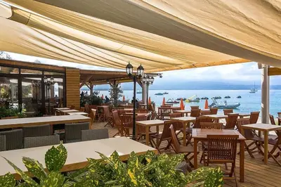 a restaurant with tables and chairs and a view of the ocean at Parking gratuit grande terrasse Proche Centre Ville in Ajaccio