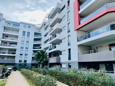 a large apartment building with a sidewalk in front of it at Parking gratuit grande terrasse Proche Centre Ville in Ajaccio