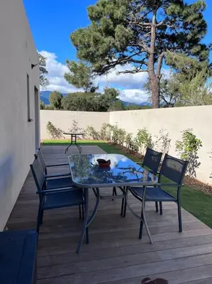 a table and two chairs on a wooden deck at Villa piscine à 1km plage proche porto vecchio in Lecci
