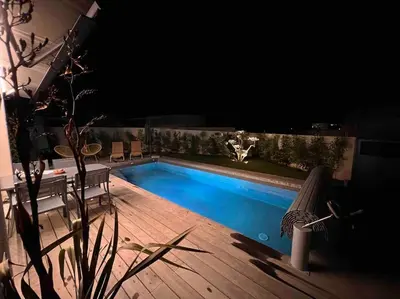 a swimming pool in a backyard at night at Villa piscine à 1km plage proche porto vecchio in Lecci