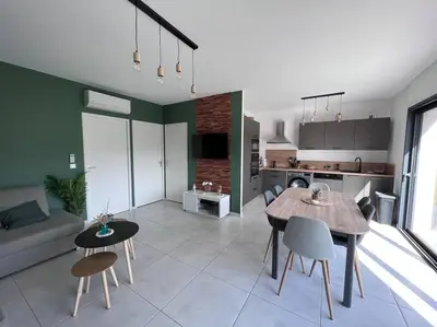 a kitchen and living room with a table and chairs at Villa piscine à 1km plage proche porto vecchio in Lecci