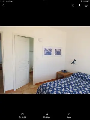 a bedroom with a bed and a white door at Maison Maquis - la vue, le silence, la mer in Tizzano
