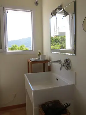 a bathroom with a white sink and a mirror at Maison Maquis - la vue, le silence, la mer in Tizzano
