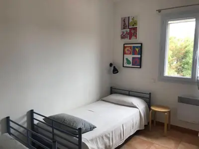 a small bedroom with a bed and a window at Maison Maquis - la vue, le silence, la mer in Tizzano