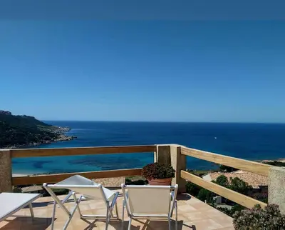 a balcony with chairs and a view of the ocean at Maison Maquis - la vue, le silence, la mer in Tizzano