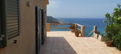 a balcony of a house with a view of the ocean at Maison Maquis - la vue, le silence, la mer in Tizzano