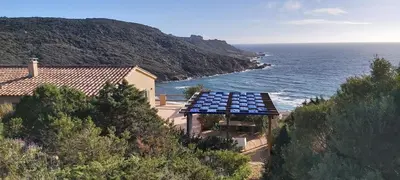 a house with a lot of solar panels on the ocean at Maison Maquis - la vue, le silence, la mer in Tizzano