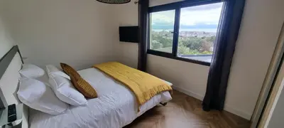 a bedroom with a bed with a large window at Palazzu B reservation 3 nuits minimum in Ajaccio