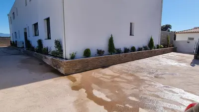 a white building with potted plants on the side of it at Palazzu B reservation 3 nuits minimum in Ajaccio