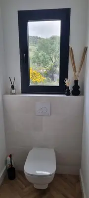 a bathroom with a white toilet and a window at Palazzu B reservation 3 nuits minimum in Ajaccio