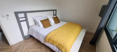 a bedroom with a bed with a yellow blanket on it at Palazzu B reservation 3 nuits minimum in Ajaccio