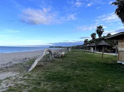 a beach with a row of benches and the ocean at Grand T2 terrasse 27m2 plein sud Folelli centre in Folelli