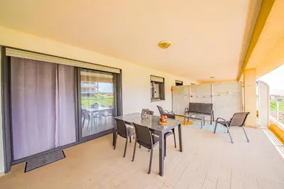 a dining room with a table and chairs at Grand T2 terrasse 27m2 plein sud Folelli centre in Folelli