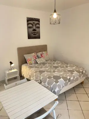 a bedroom with a bed and a table and a picture at T1 Centre ville Carré d'or proche plage in Ajaccio