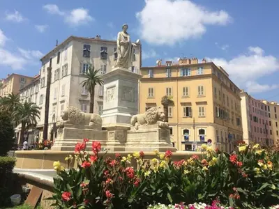 a statue in front of a building with flowers at T1 Centre ville Carré d'or proche plage in Ajaccio