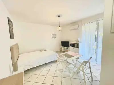 a bedroom with a bed and a desk and a table at T1 Centre ville Carré d'or proche plage in Ajaccio