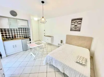 a bedroom with a bed and a table and a kitchen at T1 Centre ville Carré d'or proche plage in Ajaccio