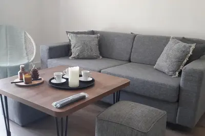 a living room with a couch and a coffee table at Très joli appartement T3 fraîchement rénové, dans résidence hôtellière in Lecci