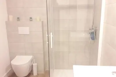 a bathroom with a shower with a toilet and a sink at Très joli appartement T3 fraîchement rénové, dans résidence hôtellière in Lecci